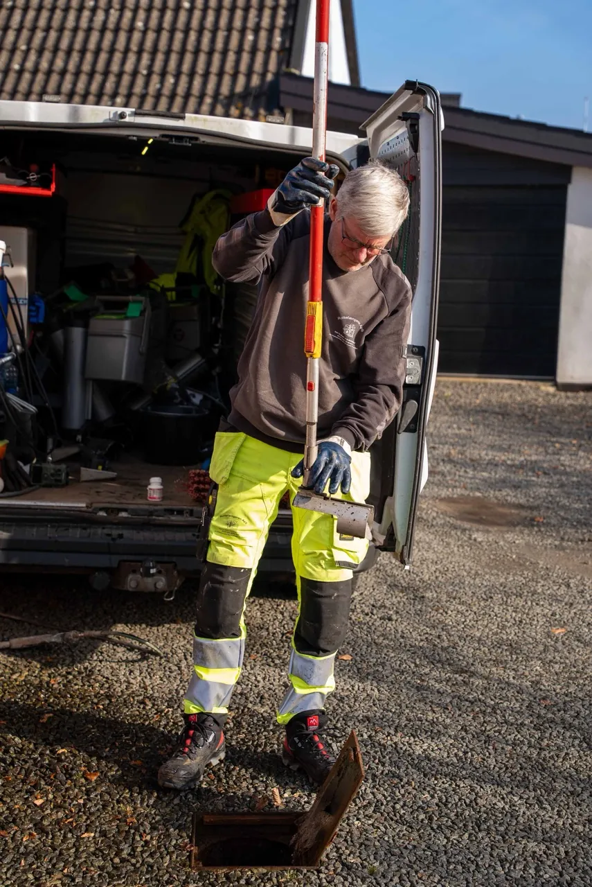 Rottefænger fra Rottefængeren ApS udfører rotteinspektion ved kloakdæksel